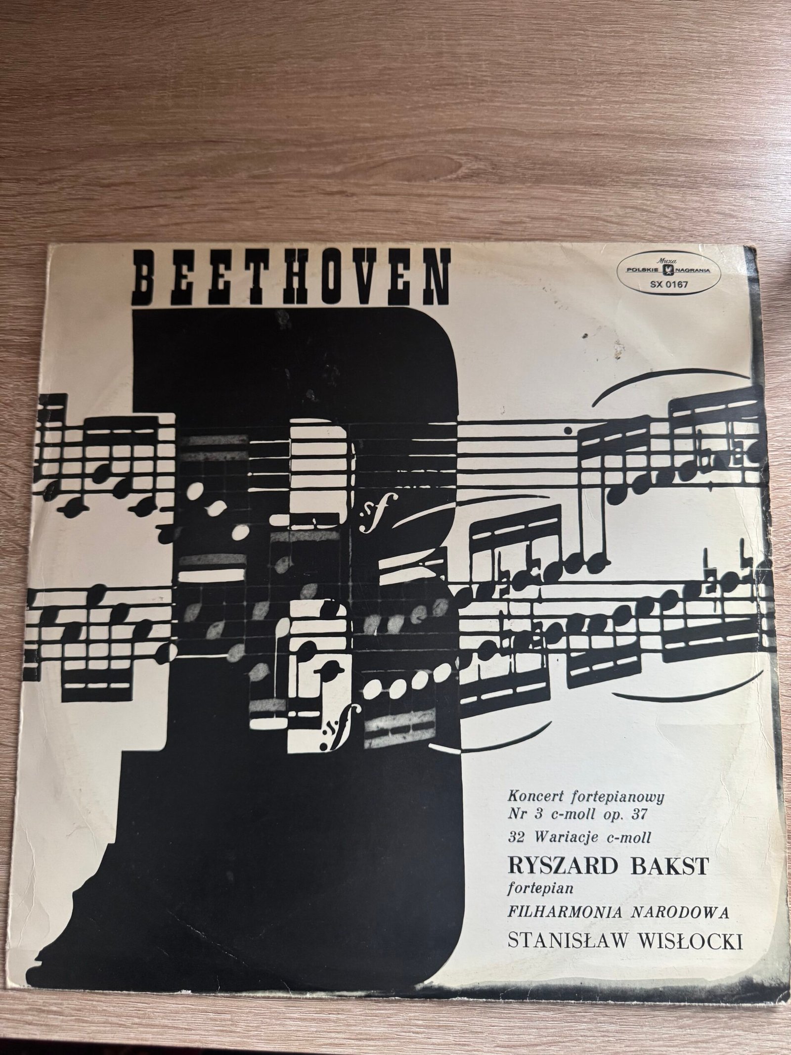 ### 1. Nazwa produktu ```text Ludwig van Beethoven – III Koncert fortepianowy c-moll op. 37 / 32 Wariacje c-moll – Ryszard Bakst, Stanisław Wisłocki ``` ### 2. Główny opis produktu ```text Polskie wydanie winylowe utworów Ludwiga van Beethovena w wykonaniu pianisty Ryszarda Baksta. Na płycie znajduje się III Koncert fortepianowy c-moll op. 37 w wykonaniu Ryszarda Baksta z Orkiestrą Symfoniczną Filharmonii Narodowej pod dyrekcją Stanisława Wisłockiego oraz 32 Wariacje c-moll na temat oryginalny na fortepian solo. Program: Ludwig van Beethoven – III Koncert fortepianowy c-moll op. 37 I. Allegro con brio II. Largo III. Rondo. Allegro Ludwig van Beethoven – 32 Wariacje c-moll na temat oryginalny Fortepian: Ryszard Bakst Dyrygent: Stanisław Wisłocki Orkiestra: Orkiestra Symfoniczna Filharmonii Narodowej w Warszawie Wydawca: Polskie Nagrania Muza Numer katalogowy: SX 0167 Kraj wydania: Polska ``` ### 3. Cena proponowana ```text 49 PLN ``` ### 4. Numer SKU ```text WIN-049 ``` ### 5. Wymiary ```text Płyta LP: średnica ok. 30 cm Okładka: ok. 31,5 × 31,5 cm ``` ### 6. Autor / producent ```text Kompozytor: Ludwig van Beethoven Fortepian: Ryszard Bakst Dyrygent: Stanisław Wisłocki Orkiestra: Orkiestra Symfoniczna Filharmonii Narodowej w Warszawie Wydawca: Polskie Nagrania Muza Numer katalogowy: SX 0167 Kraj wydania: Polska ``` ### 7. Okres powstania ```text XX wiek, wydanie z okresu PRL. ``` ### 8. Materiał / technika ```text Płyta winylowa LP 12", 33⅓ RPM, nagranie stereofoniczne, tłoczenie Polskie Nagrania Muza. ``` ### 9. Wymiary opisowe ```text Standardowa płyta długogrająca LP o średnicy około 30 cm, w oryginalnej drukowanej okładce kartonowej. ``` ### 10. Stan zachowania i uszkodzenia ```text Stan używany, z widocznymi śladami wieku i użytkowania. Okładka zachowana w całości, z przetarciami, zabrudzeniami, zagnieceniami oraz śladami zużycia na krawędziach i narożnikach. Płyta posiada powierzchniowe ślady użytkowania i drobne rysy widoczne na zdjęciach. Płyta nie była oceniana odsłuchowo ani profesjonalnie klasyfikowana według skali gradingowej. ``` ### 11. Pochodzenie ```text Prywatna kolekcja taty; egzemplarz odziedziczony. ``` ### 12. Historia / przekaz rodzinny ```text Płyta pochodzi z prywatnej kolekcji muzycznej taty i przez wiele lat była przechowywana jako część rodzinnego zbioru płyt winylowych. ``` ### 13. Znaczniki produktu ```text Ludwig van Beethoven, Beethoven, Ryszard Bakst, Stanisław Wisłocki, Filharmonia Narodowa, Orkiestra Symfoniczna Filharmonii Narodowej, III Koncert fortepianowy, Koncert fortepianowy c-moll op. 37, Piano Concerto No. 3, 32 Wariacje c-moll, 32 Variations in C minor, Polskie Nagrania Muza, SX 0167, muzyka klasyczna, fortepian, piano, orkiestra symfoniczna, winyl, płyta winylowa, LP, polskie winyle, vintage vinyl, classical vinyl ``` ### 14. Krótki opis produktu ```text Ludwig van Beethoven – III Koncert fortepianowy c-moll op. 37 oraz 32 Wariacje c-moll w wykonaniu Ryszarda Baksta. Orkiestrą Symfoniczną Filharmonii Narodowej dyryguje Stanisław Wisłocki. Polskie wydanie Polskie Nagrania Muza, numer katalogowy SX 0167. Egzemplarz z prywatnej rodzinnej kolekcji. ```
